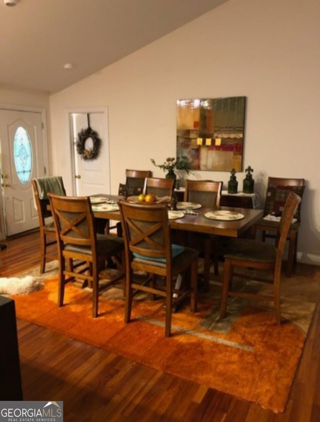 dining space with wood-type flooring and lofted ceiling