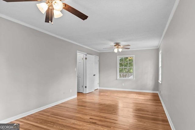 unfurnished room featuring ceiling fan, light wood-type flooring, and ornamental molding