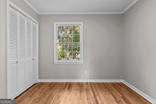 unfurnished bedroom with crown molding, a closet, and light hardwood / wood-style floors