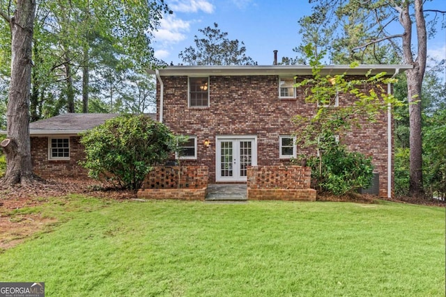 rear view of house with french doors and a lawn