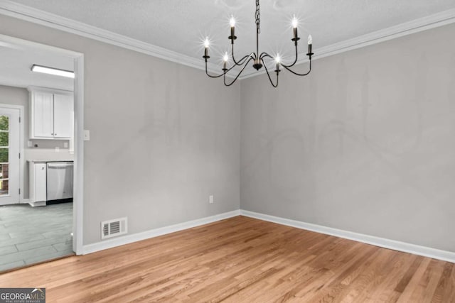 unfurnished dining area with a notable chandelier, crown molding, light hardwood / wood-style flooring, and a textured ceiling