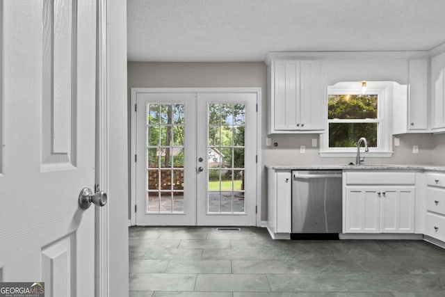 kitchen with french doors, white cabinets, stainless steel dishwasher, and a healthy amount of sunlight