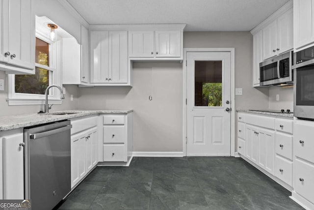 kitchen with stainless steel appliances, sink, light stone counters, and white cabinetry