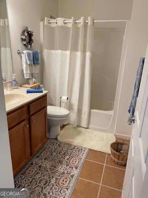 full bathroom featuring tile patterned floors, toilet, shower / bath combo with shower curtain, and vanity