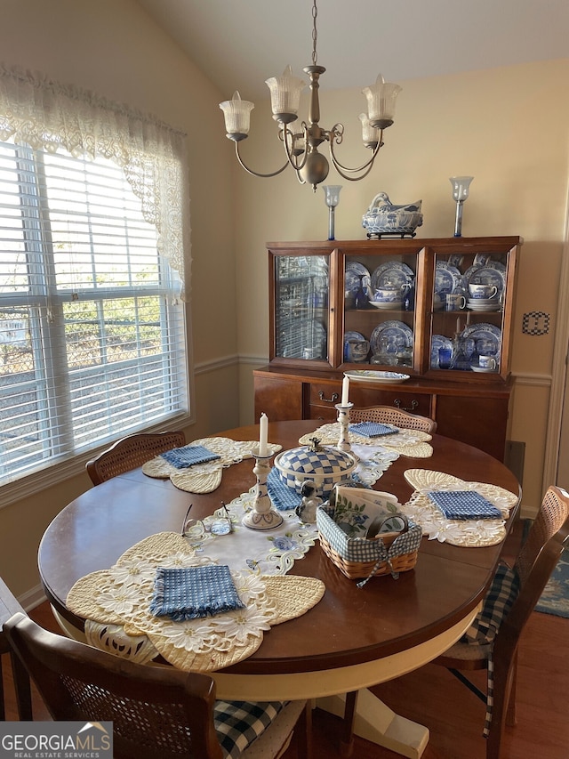 dining room with lofted ceiling and a notable chandelier