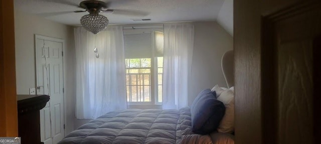 bedroom with a textured ceiling, ceiling fan, and lofted ceiling