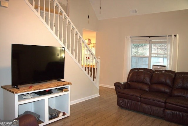 living room with wood-type flooring and high vaulted ceiling