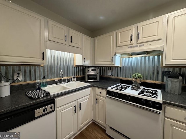 kitchen with sink, white cabinets, dark hardwood / wood-style floors, and white appliances