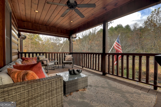 wooden deck featuring outdoor lounge area and ceiling fan