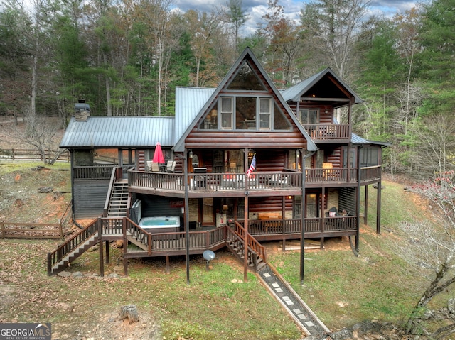 rear view of house featuring a hot tub