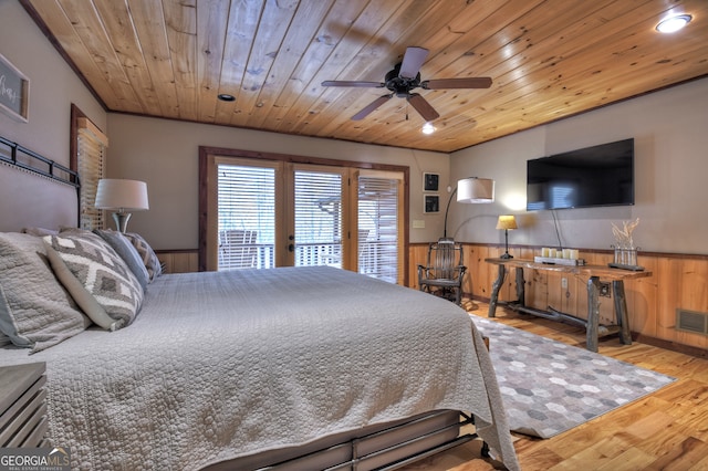 bedroom with wood walls, ceiling fan, wood ceiling, and light wood-type flooring