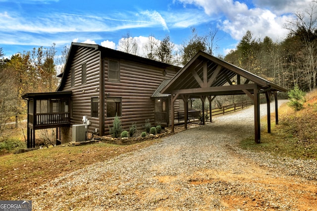 view of front of home with central air condition unit and a carport