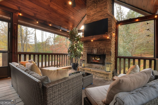 sunroom / solarium featuring wooden ceiling, an outdoor stone fireplace, and vaulted ceiling