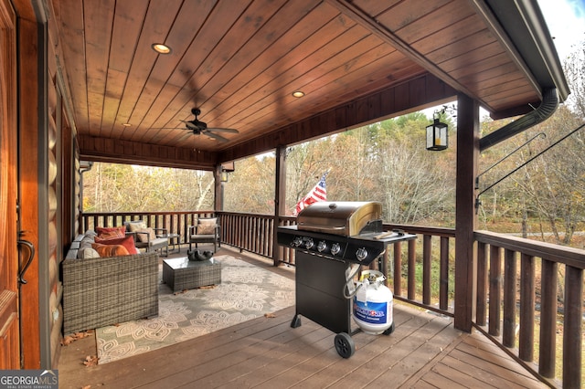 wooden terrace featuring area for grilling, ceiling fan, and an outdoor living space