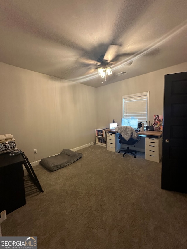 carpeted office space with a textured ceiling and ceiling fan