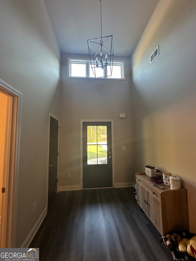 foyer entrance featuring a high ceiling, dark hardwood / wood-style floors, and plenty of natural light