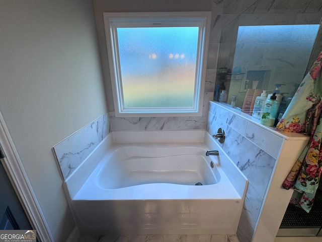 bathroom with a bath and plenty of natural light