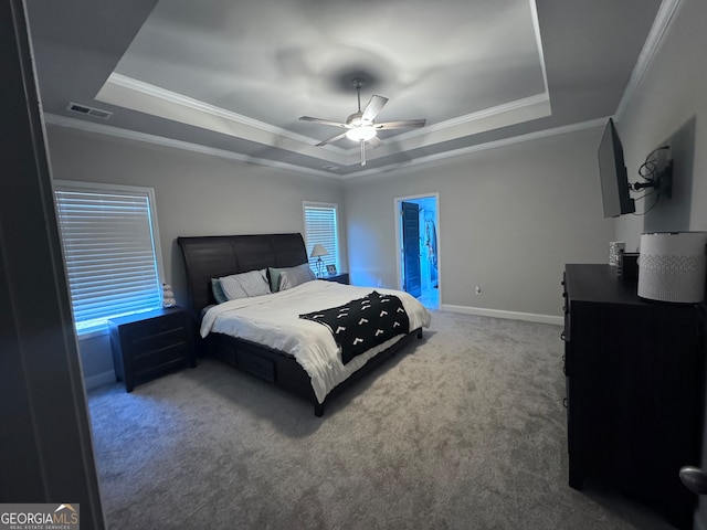 carpeted bedroom with ensuite bath, crown molding, a tray ceiling, and ceiling fan