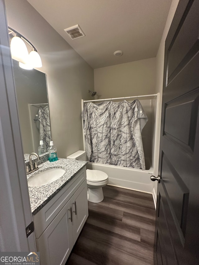 full bathroom featuring shower / bath combo with shower curtain, hardwood / wood-style floors, toilet, and vanity