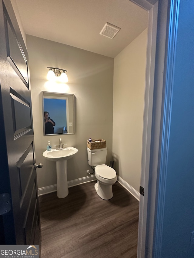 bathroom with toilet and wood-type flooring