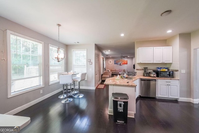 kitchen with pendant lighting, white cabinets, kitchen peninsula, stainless steel appliances, and dark hardwood / wood-style flooring