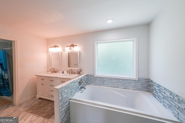 bathroom with vanity and a bath