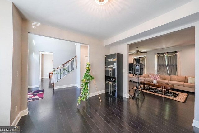 living room featuring ceiling fan and dark hardwood / wood-style flooring