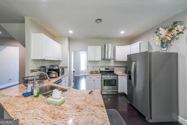 kitchen featuring wall chimney exhaust hood, dark wood-type flooring, sink, white cabinets, and appliances with stainless steel finishes