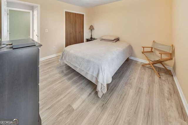 bedroom with a closet and light hardwood / wood-style floors