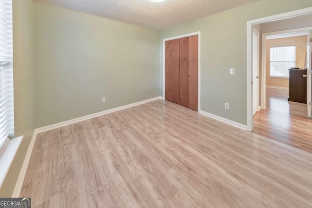 interior space with a textured ceiling and light hardwood / wood-style flooring