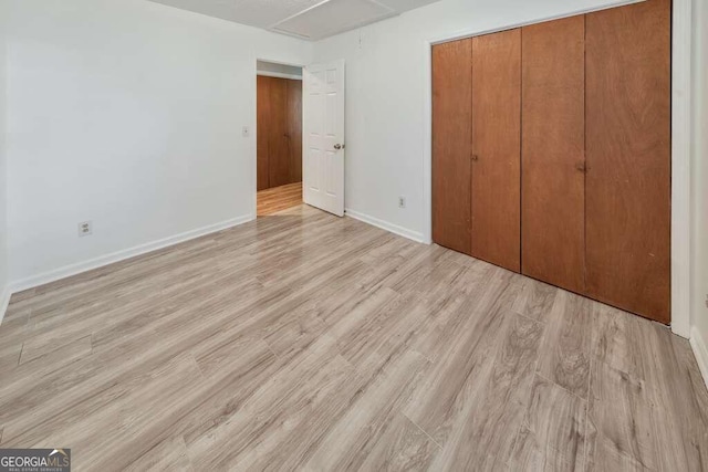 unfurnished bedroom featuring a closet and light hardwood / wood-style floors