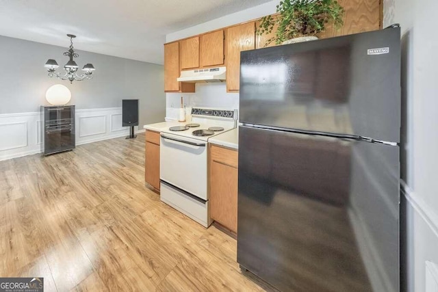 kitchen with hanging light fixtures, stainless steel fridge, white range with electric cooktop, an inviting chandelier, and light wood-type flooring