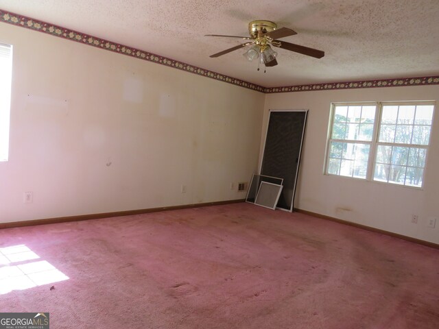 unfurnished room with ceiling fan, carpet floors, and a textured ceiling