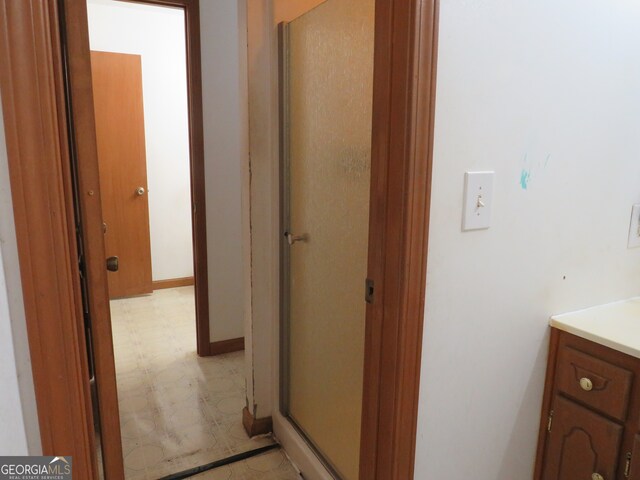 bathroom with a shower with shower door and vanity