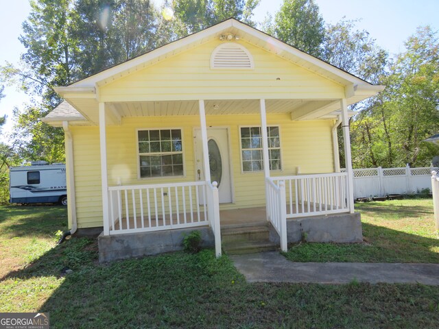 bungalow-style house featuring a front lawn and covered porch