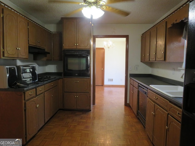 402 Thurman Rd, Stockbridge, GA 30281 - kitchen with black oven, dark countertops, ceiling fan, dishwashing machine, and under cabinet range hood