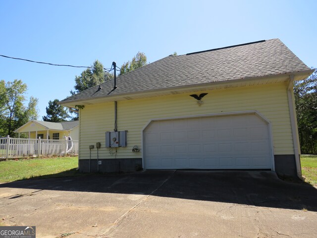 view of side of home with a yard and a garage