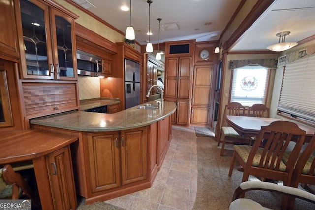 kitchen featuring ornamental molding, sink, decorative light fixtures, stainless steel appliances, and dark stone countertops