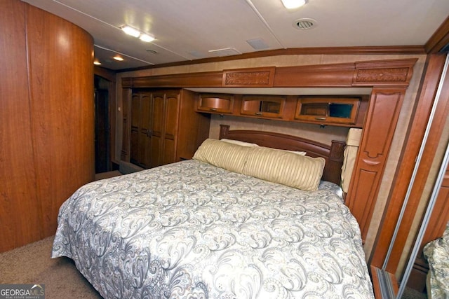 carpeted bedroom featuring lofted ceiling, crown molding, and wooden walls