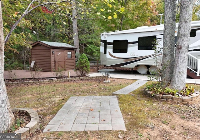 view of yard with a storage shed and a patio area