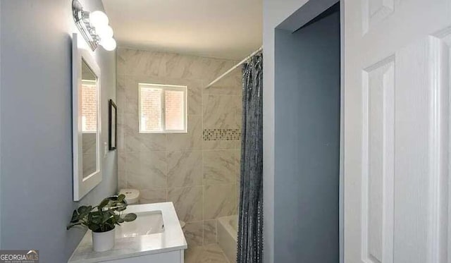 bathroom featuring shower / bath combo with shower curtain and vanity