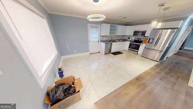 kitchen featuring sink, stainless steel appliances, hanging light fixtures, white cabinets, and ornamental molding