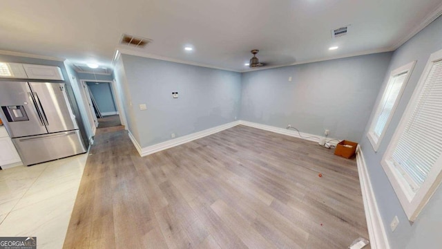 spare room featuring ceiling fan, light wood-type flooring, and ornamental molding