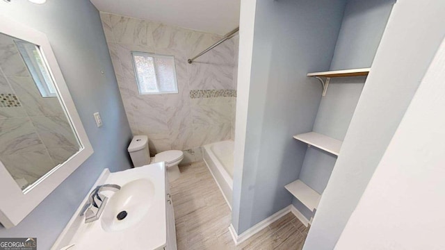 full bathroom with tiled shower / bath combo, hardwood / wood-style flooring, vanity, and toilet