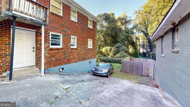 view of property exterior with a patio and a balcony