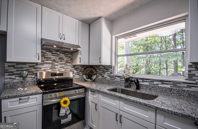 kitchen featuring stainless steel range, white cabinets, sink, and a textured ceiling