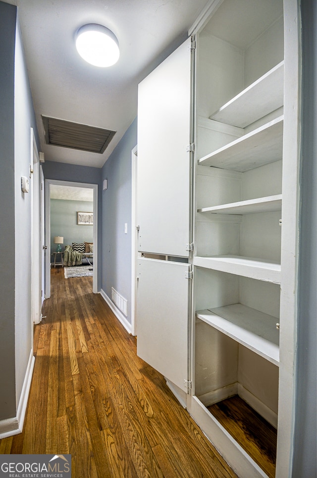 hallway with dark hardwood / wood-style flooring