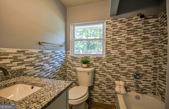 full bathroom with shower / tub combination, vanity, tile walls, and toilet