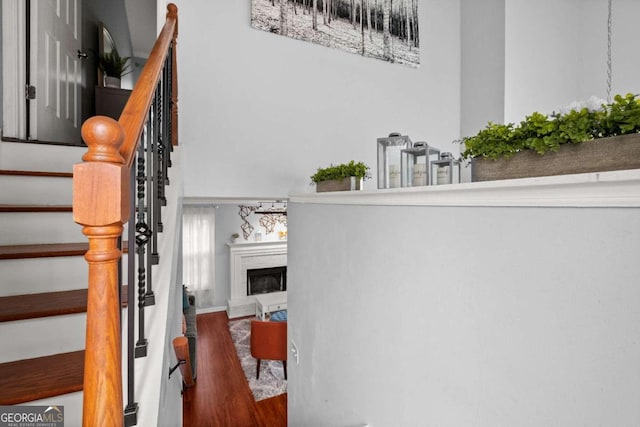 stairway featuring a fireplace and hardwood / wood-style flooring