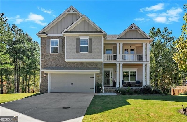 craftsman house with a balcony, a garage, and a front lawn